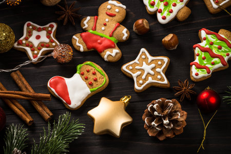 Christmas gingerbread in the plate with spices and decorations on dark wooden table.