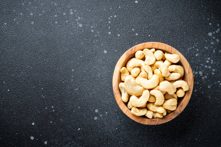 Cashew nuts in bowl at black background.の写真素材