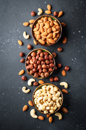 Nuts assortment in bowls at black background.の写真素材