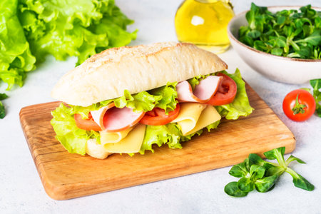 Ciabatta sandwich with lettuce, cheese, tomatoes and ham.の写真素材