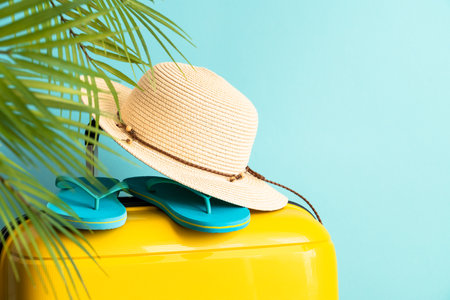 Suitcase, hat and flip flops on blue background.の写真素材