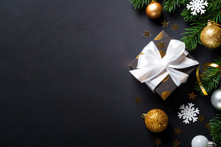 Black christmas background. Christmas present with golden decorationsの写真素材