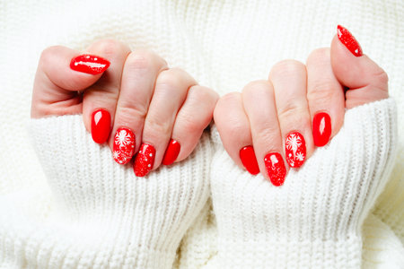 Christmas manicure, red nails on white background.の写真素材