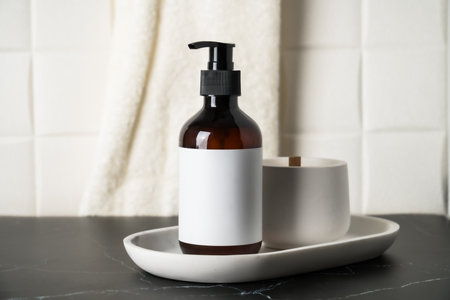 Shampoo bottle with pump at white background and towels.の写真素材