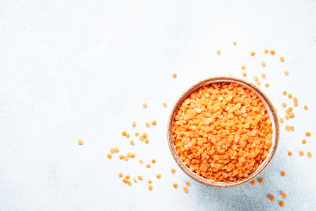 Red lentils in craft bowl on white background.の写真素材