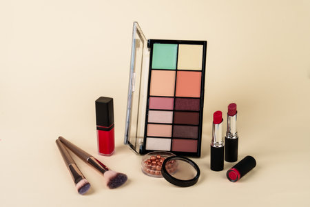 Makeup products. Eyeshadow palette, lipsticks and brushes on pastel background.の写真素材