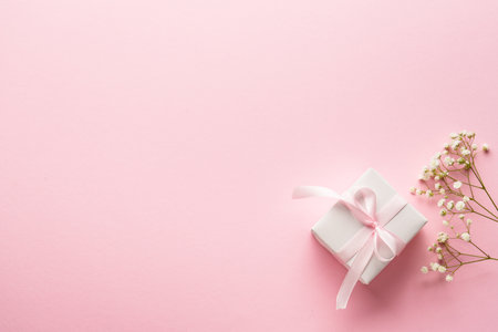 Pink flat lay background. Gift box with white flowers.の写真素材