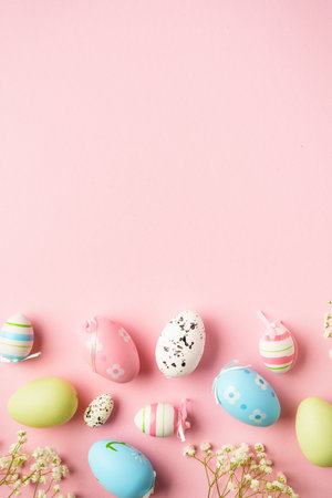 Easter eggs background on pink. Colored eggs, flowers. Flat lay with copy space.の写真素材