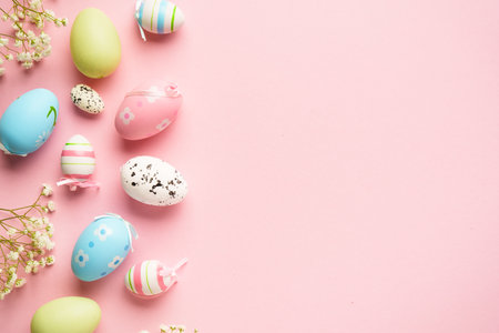 Easter background flat lay on pink. Colored eggs and flowers with copy space.の写真素材