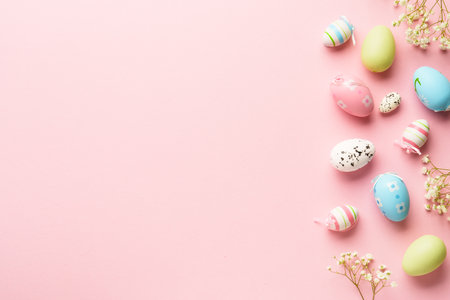 Easter eggs background on pink. Colored eggs, flowers. Flat lay with copy space.の写真素材