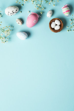 Easter eggs. Easter holidays composition with cute decorations and flowers. Top view on blue background.の写真素材