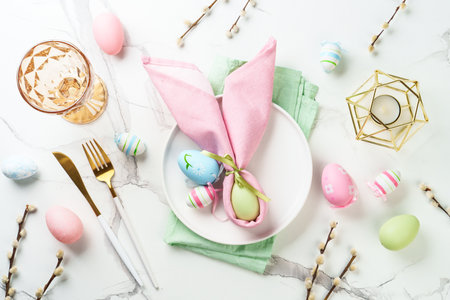 Easter table setting on white background. White plate, cutlery and easter decorations. Flat lay.の写真素材