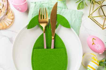Easter food with cute decorations on white background. White plate, cutlery and funny easter...