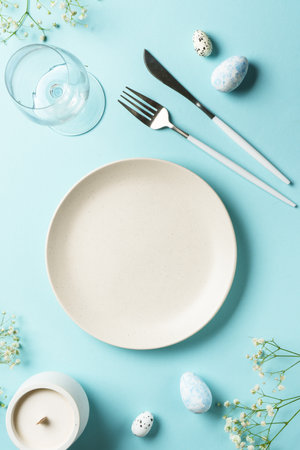 Easter table with eggs and flowers. Top view on blue background.の写真素材