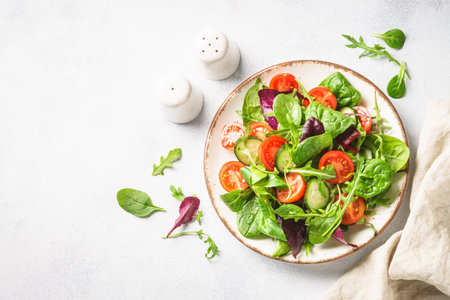 Salad from green leaves and vegetables. Fresh green salad in white plate. Top view.の写真素材
