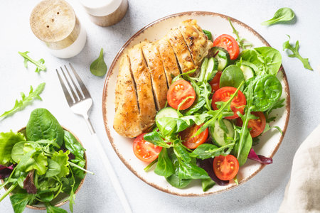 Green salad with chicken fillet on white. Diet food, healthy nutrition. Top view with copy space.の写真素材