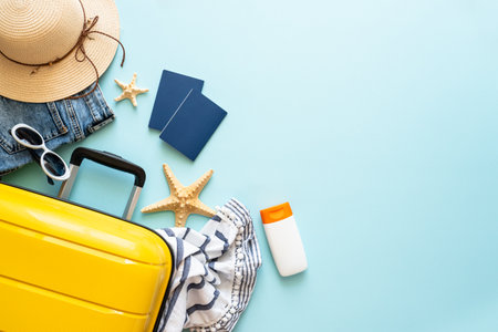 Travel background, summer holidays. Suitcase, passports, hat and summer cloth on blue background. Flat lay image with copy space.の写真素材
