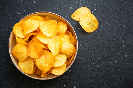 Chips on black table. Top view with copy space.の写真素材