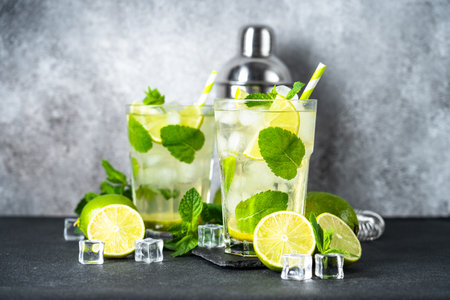 Mojito with rum, mint and lime on black background. Tradition Summer drink with shaker and bar utensils.の写真素材