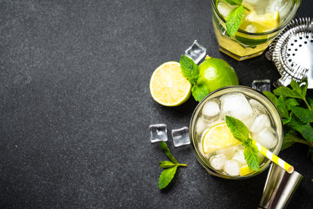 Mojito with rum, lime, mint and ice on black background. Traditional Summer drink. Flat lay.の写真素材