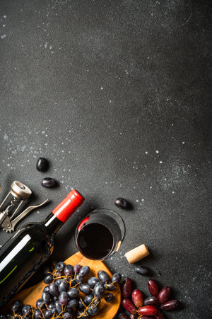 Red Wine at black background. Glass of wine, bottle and grapes. Top view with copy space.の写真素材