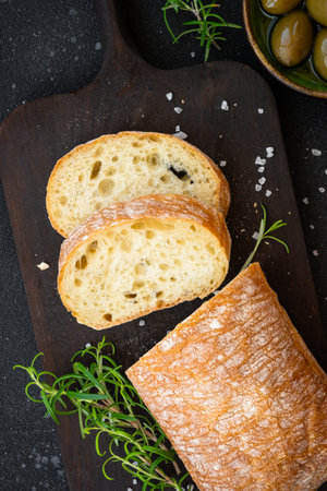 Ciabatta bread on wooden board on black background. Top view with copy space.の写真素材