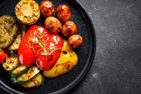 Grilled vegetables. Potato, paprika, zucchini, eggplants and tomato. Vegan dish. Top view with copy space.の写真素材