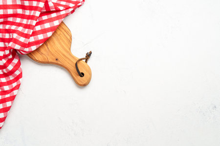 Kitchen table with wooden cutting board and red kitchen towel. Top view with space for design.の写真素材