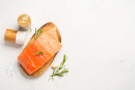 Salmon fish with herbs. Top view on white background.の写真素材