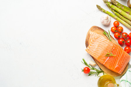 Salmon fillet with fresh vegetables. Raw ingredients for cooking. Top view with copy space on white background.の写真素材