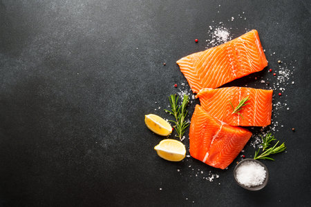 Raw salmon fillet with spices. Top view on black background.の写真素材