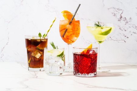 Alcohol cocktail drinks at white background. Aperol spritz, negroni, Margarita, Cuba libre and jin tonic. Sunny background.の写真素材