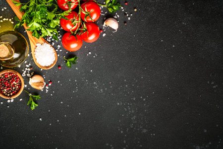 Food background with fresh vegetables, herbs and spices on black.の写真素材