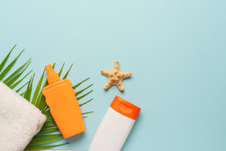 Sunscreen, towel and sunglasses on blue background.の写真素材