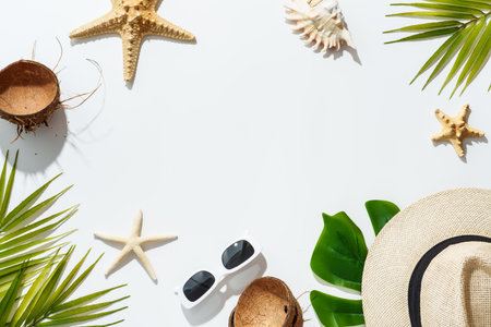 Summer accessories on white background.. Palm leaves, hat, sunglasses, sea shells and coconut. Flat lay with copy space.の写真素材