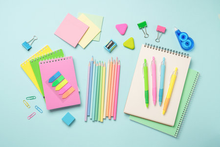 School supplies, sketch book, notepad on blue background with pensils, pens and other for school and...