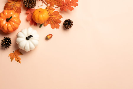 Pumpkins, spices and fallen leaves on color background. Flat lay image with space for design.