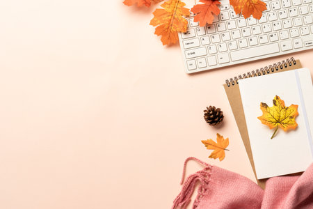 Autumn workspace flat lay background. Laptop, notebook, mug of spicy tea and scarf with yellow...