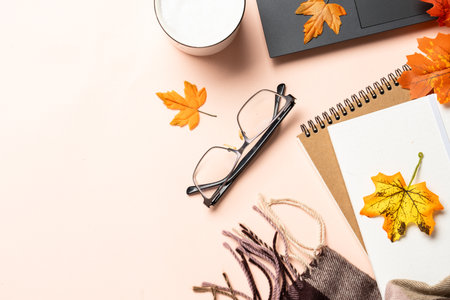 Autumn office desk. Laptop, notebook, cup of coffee and yellow leaves. Flat lay with space for text.