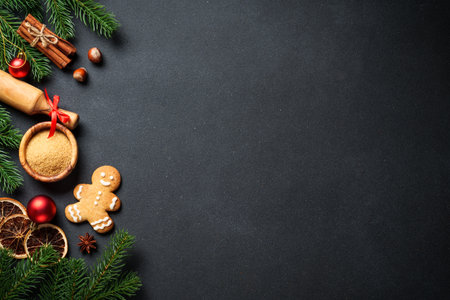 Christmas baking ingredients at black. Gingerbread cookies, spices and Christmas decorations. Flat...