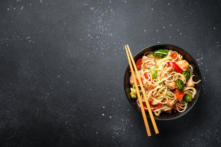Asian noodles with chicken and vegetables at black background.の写真素材