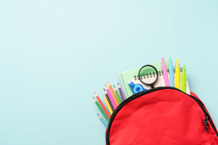 School backpack with stationery on colored background.の写真素材