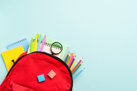 School backpack with stationery on colored background.の写真素材