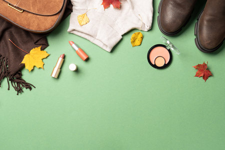 Autumn cloth and accessories at white background with copy space. Flat lay. Scarf, sweater and bag with fallen leaves.の写真素材