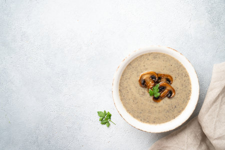 Mushroom soup puree on white kitchen table. Healthy vegan dish. Flat lay with space for design.の写真素材