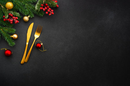 Christmas food background on black. Golden cutlery and holiday decorations. Flat lay with copy...