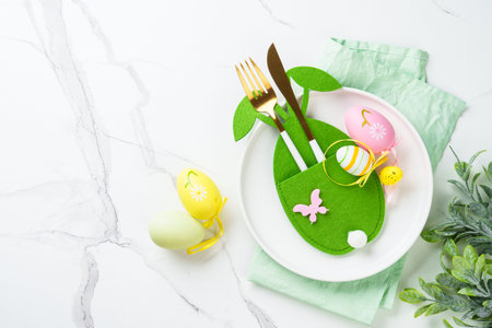 Easter table setting with cute decorations at white background.