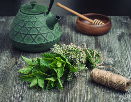 Fresh herbs: mint and thyme with a teapot.