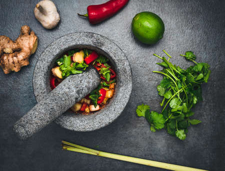 Thai mortar and pestle with spices and herbs.の写真素材