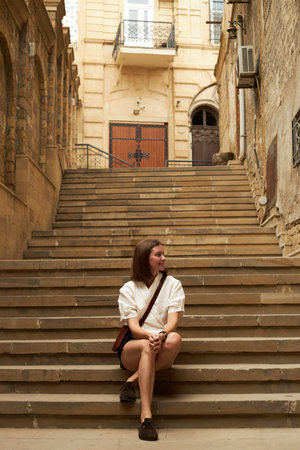 Woman sitting on the stairs in old town of Baku. Azerbaijan